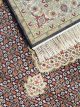 Handknotted wool oriental carpet with grid design, central motif, and black, gold, red border – luxury rug