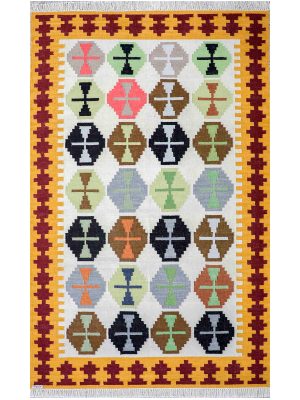 Flatwoven dhurrie with hexagon and inner link motifs in warm tones of brown, yellow, blue, and green – artisanal geometric rug